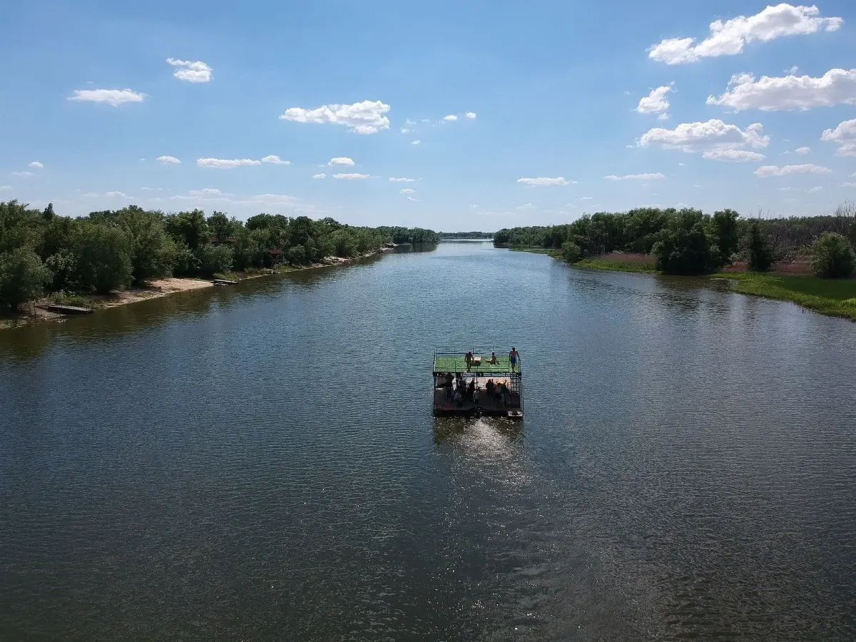 Гости празднуют на верхней палубе плота на закате
